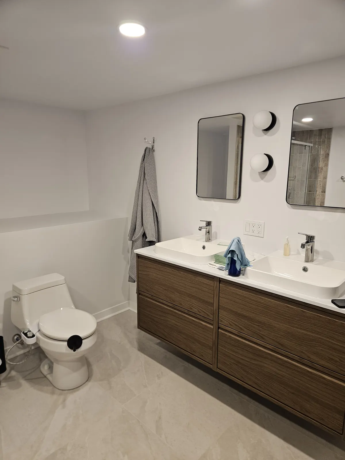 Vanité double flottante en bois dans une salle de bain claire, par Rénovations CTR